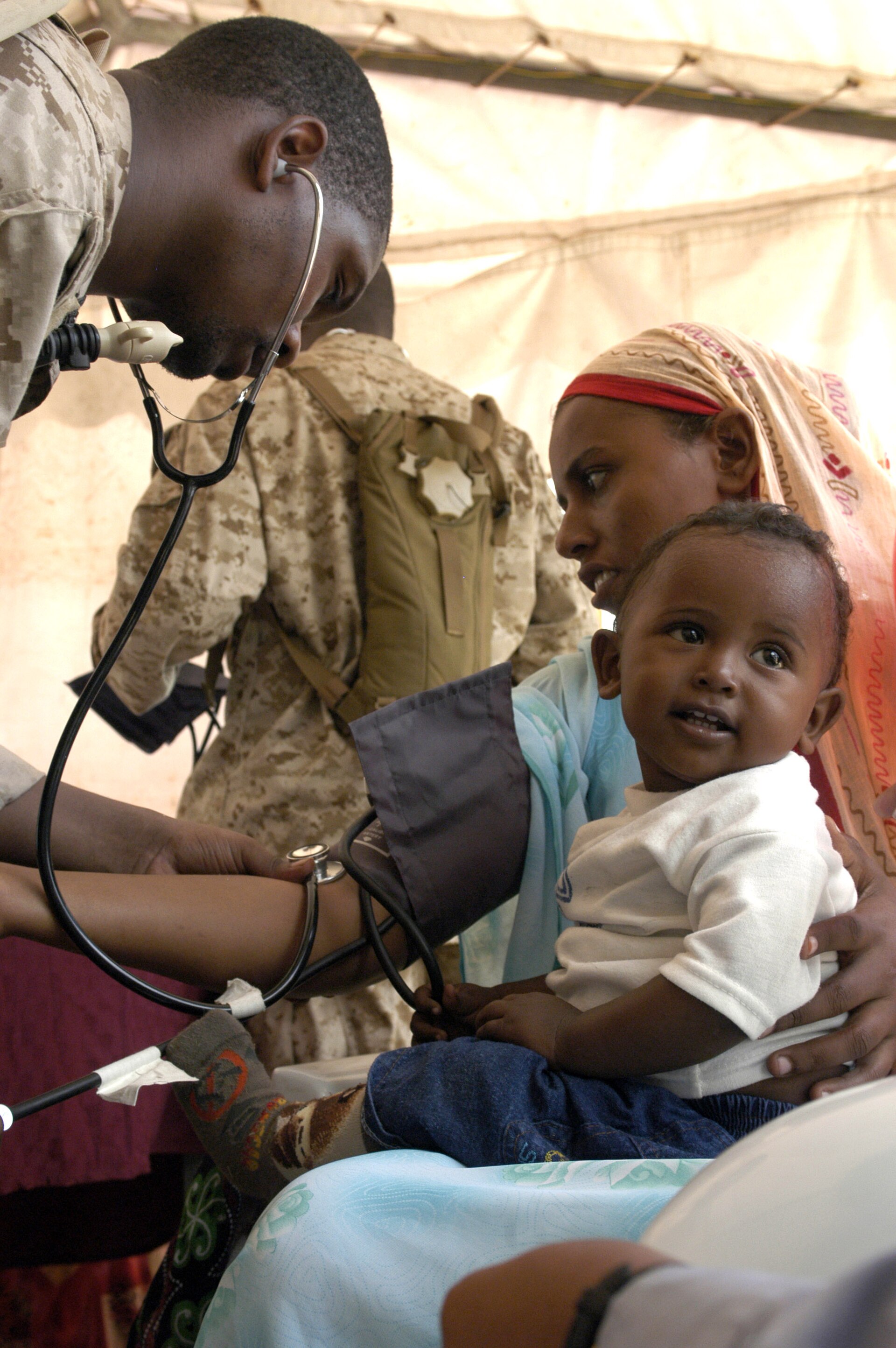 A health worker taking a Kenyan patient's blood pressure during a community medical visit